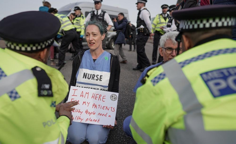 Environmental protestor on Lambeth Bridge, London, in 2022. Credit: Alisdare Hickson / Creative Commons 2.0.