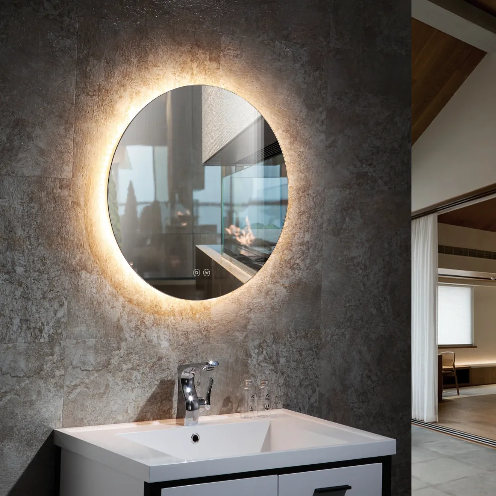Round backlit LED mirror glowing above a white basin on a charcoal stone tiled wall