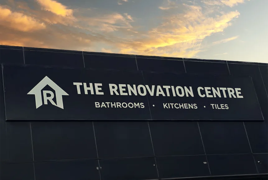 The Renovation Centre shopfront sign in charcoal at dusk, reading Bathrooms Kitchens Tiles