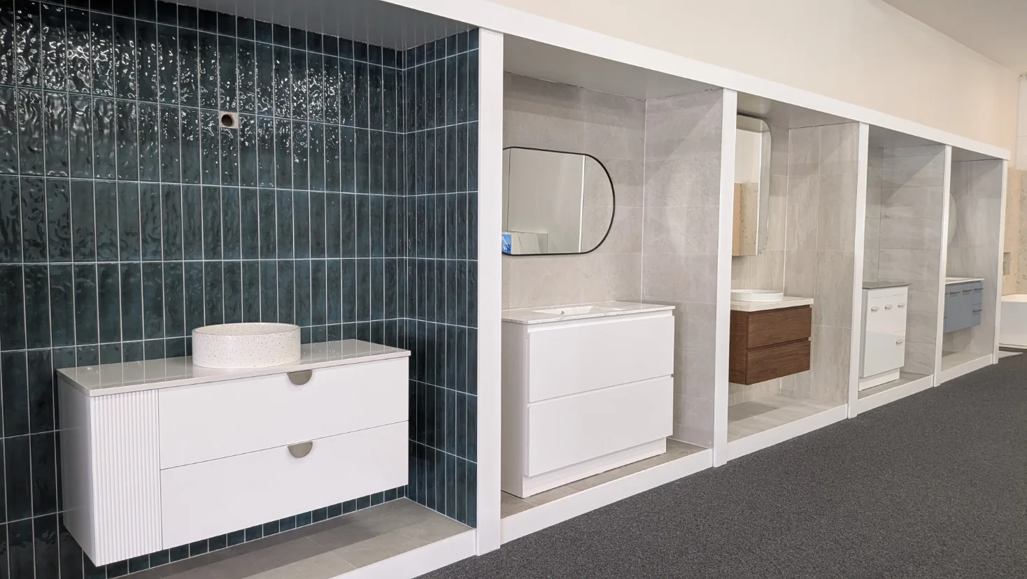 White fluted wall hung vanity against emerald green vertical tiles, with further vanity bays running down the Osborne Park showroom