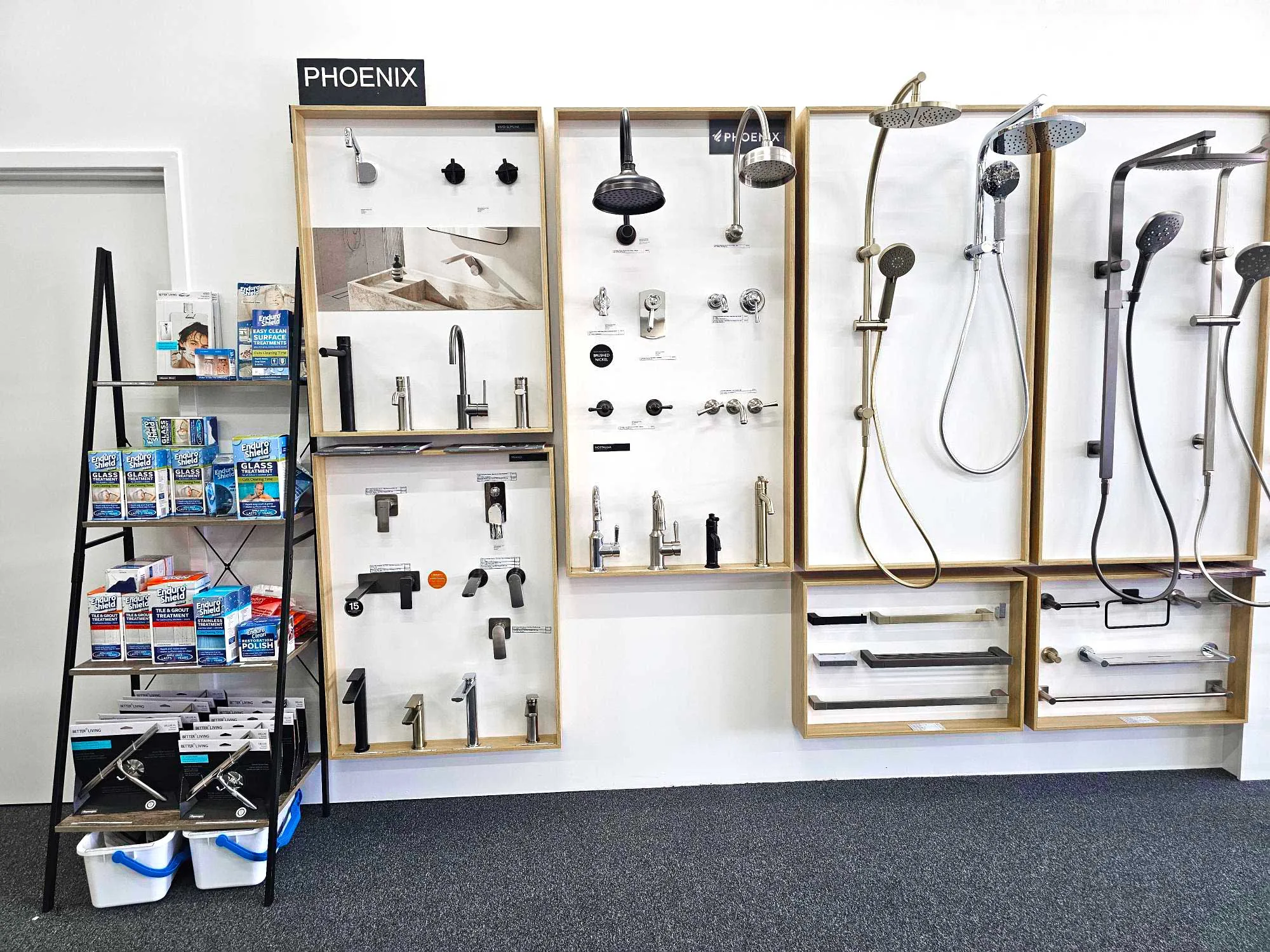 Tapware display wall at the Osborne Park showroom with basin mixers, shower rails and handpieces in matte black, chrome and brushed finishes