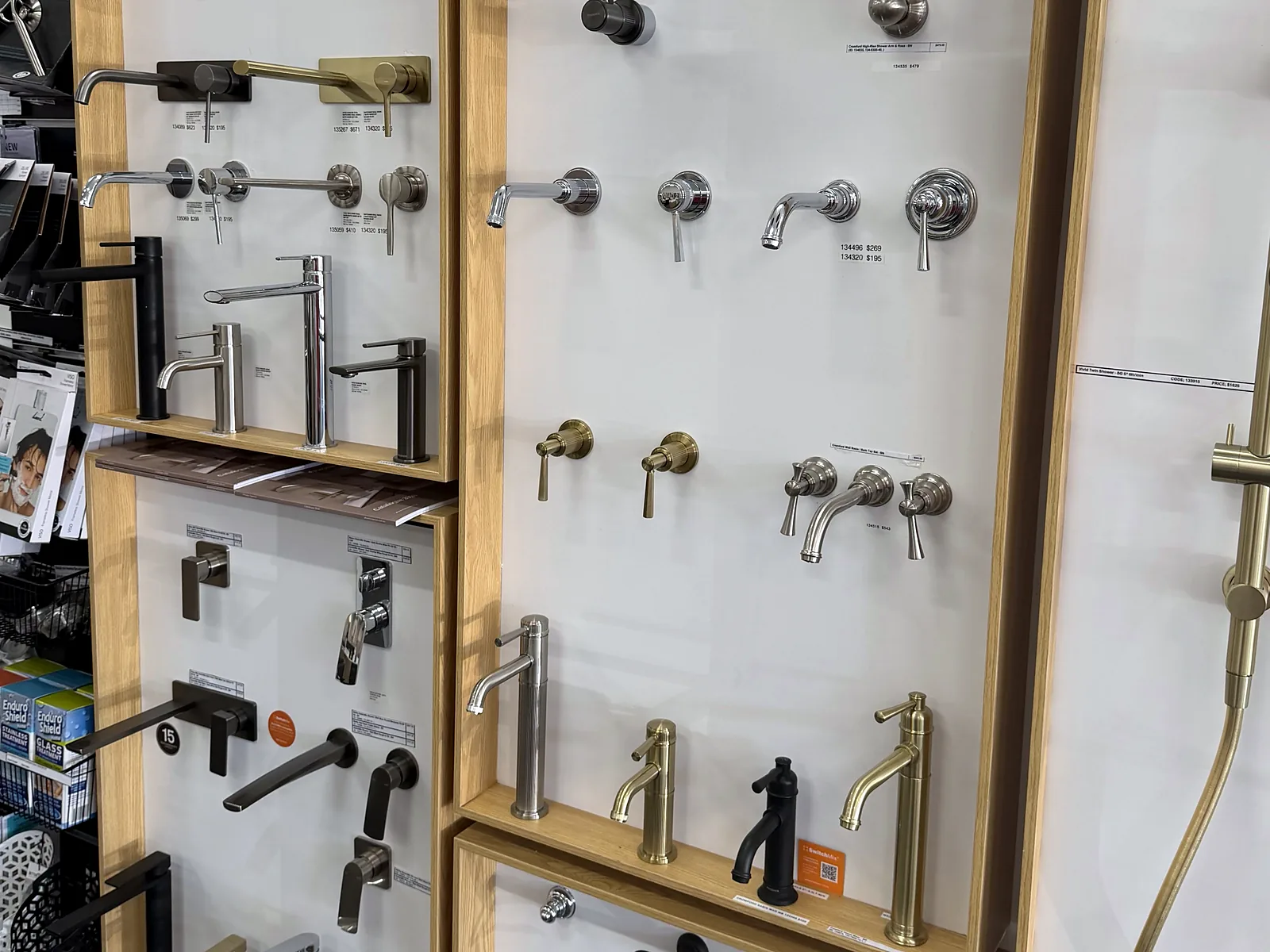 Tapware display board in the Osborne Park showroom with basin mixers and wall mixer sets in chrome, brushed brass and matte black