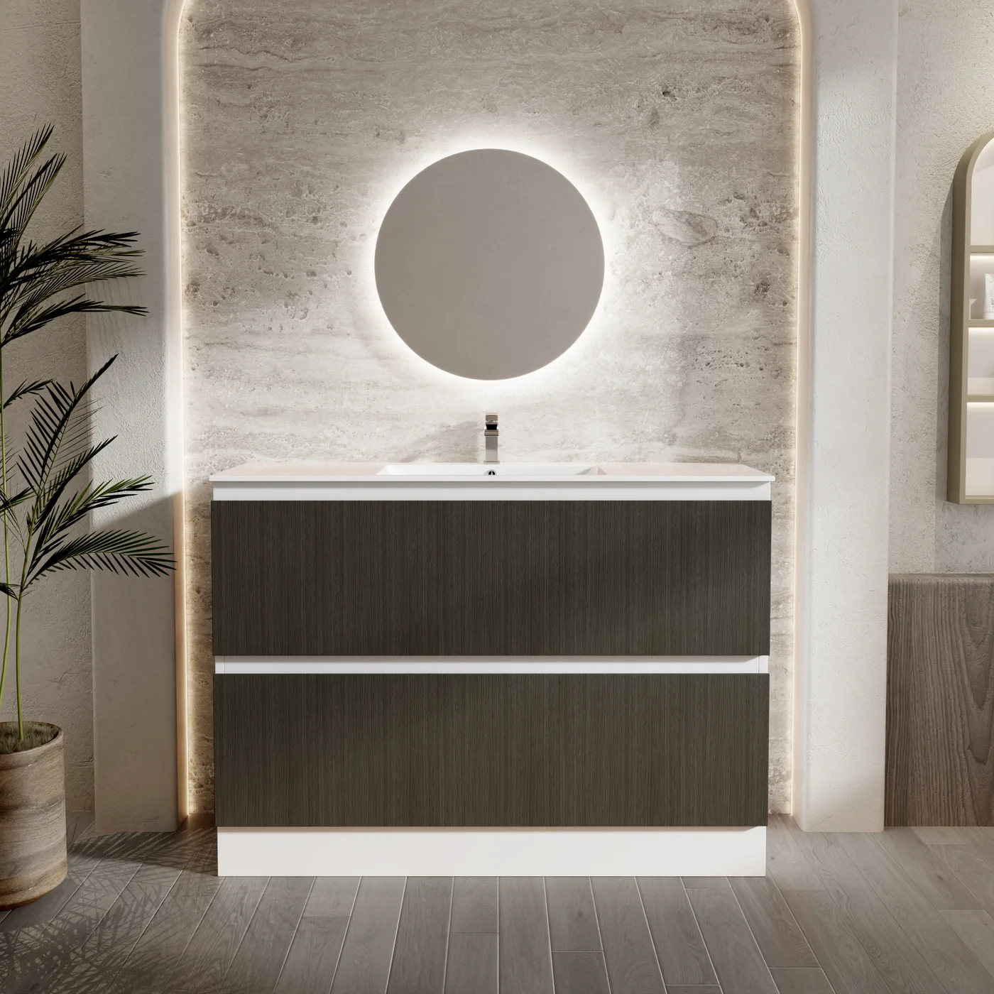 Floor standing two drawer kicker vanity in Whispering Willow dark woodgrain with a white ceramic basin top, styled under a backlit round mirror against travertine look tiles