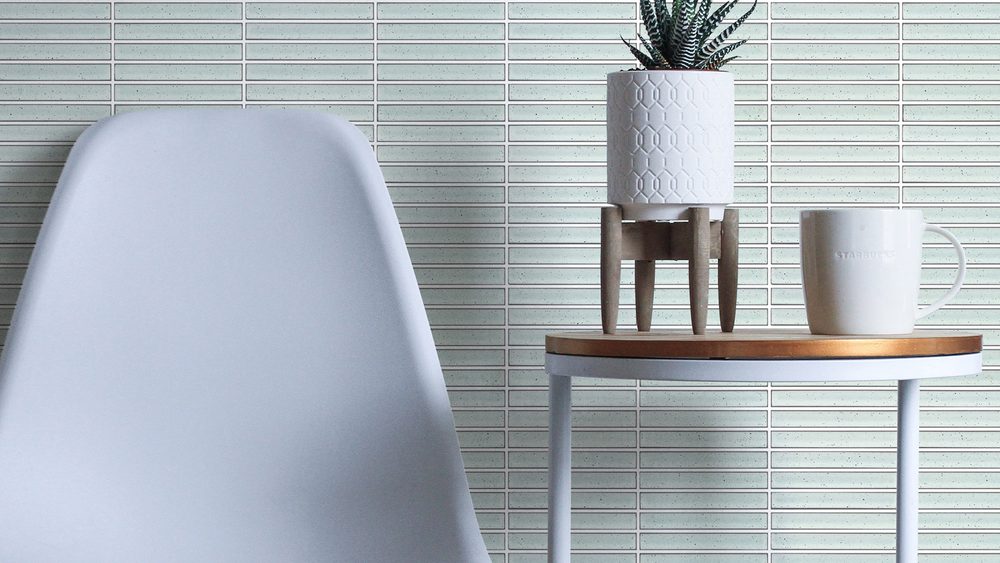Stoneworld Finger speckled white mosaic wall tiles behind a table and chair