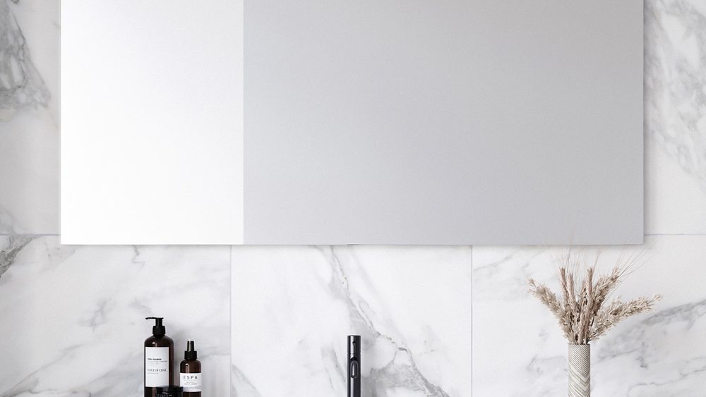 A wide frameless Timberline Georgia mirror above a bench on a marble tiled wall