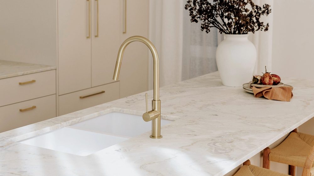 Phoenix Vivid Slimline tapware in brushed gold on a kitchen benchtop