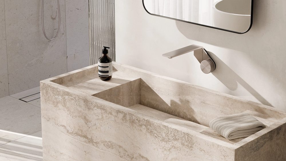 Phoenix Axia wall mixer set above a travertine basin