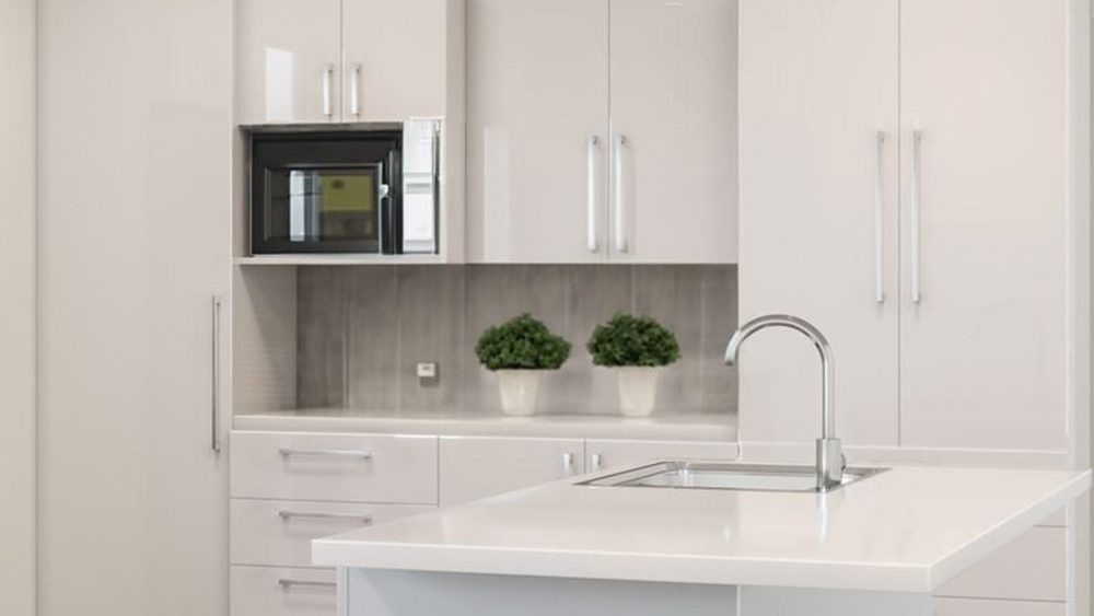 Alpine white gloss kitchen cabinetry with an island bench