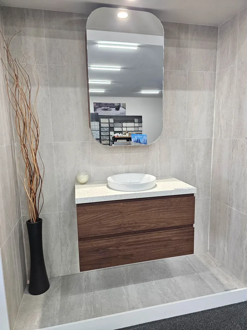 Walnut two drawer wall hung vanity, speckled stone top, round vessel basin and pill mirror