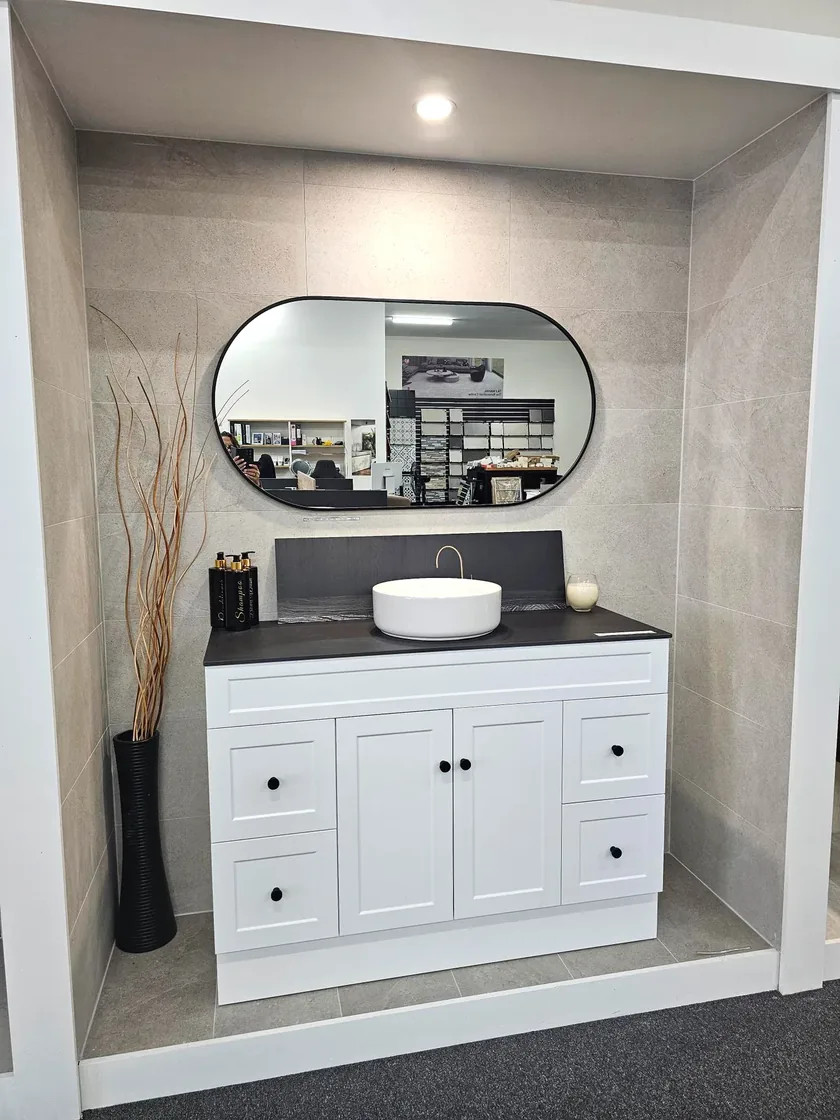 White shaker vanity, black stone top and splashback, round vessel basin and black framed oval mirror