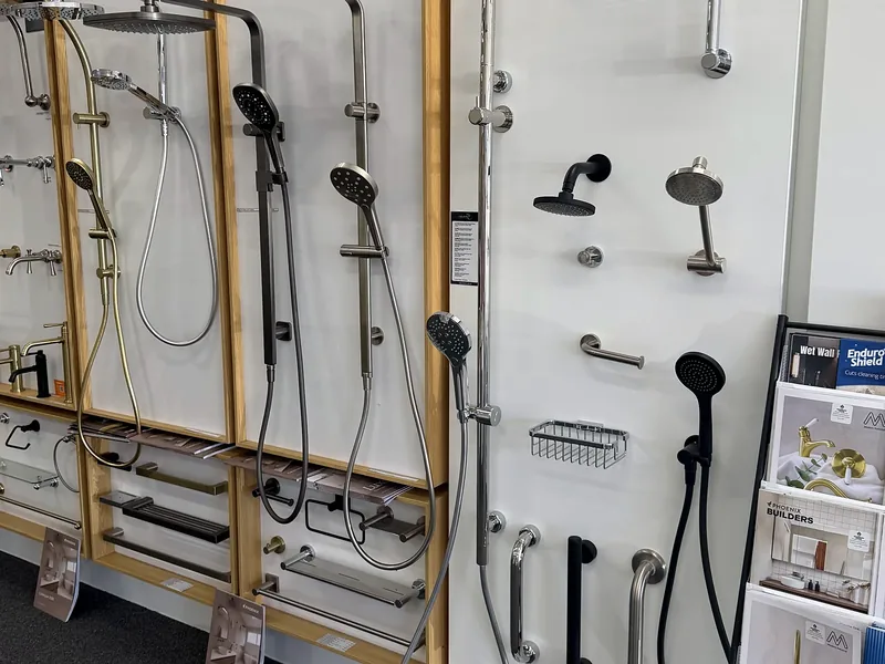 Shower rail sets, hand showers and rain heads displayed on the shower wall in the Osborne Park showroom