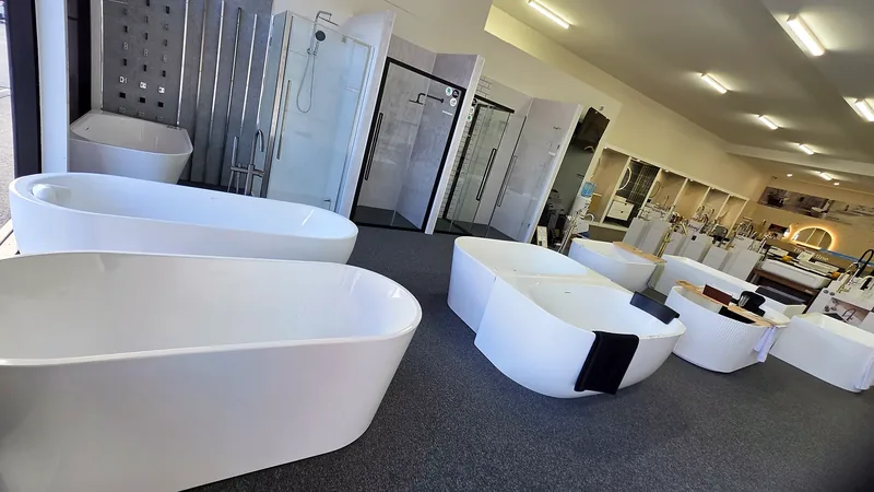 Row of freestanding baths on the showroom floor beside the shower screen displays