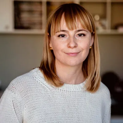 Stock headshot of a woman with bangs wearing a white sweater