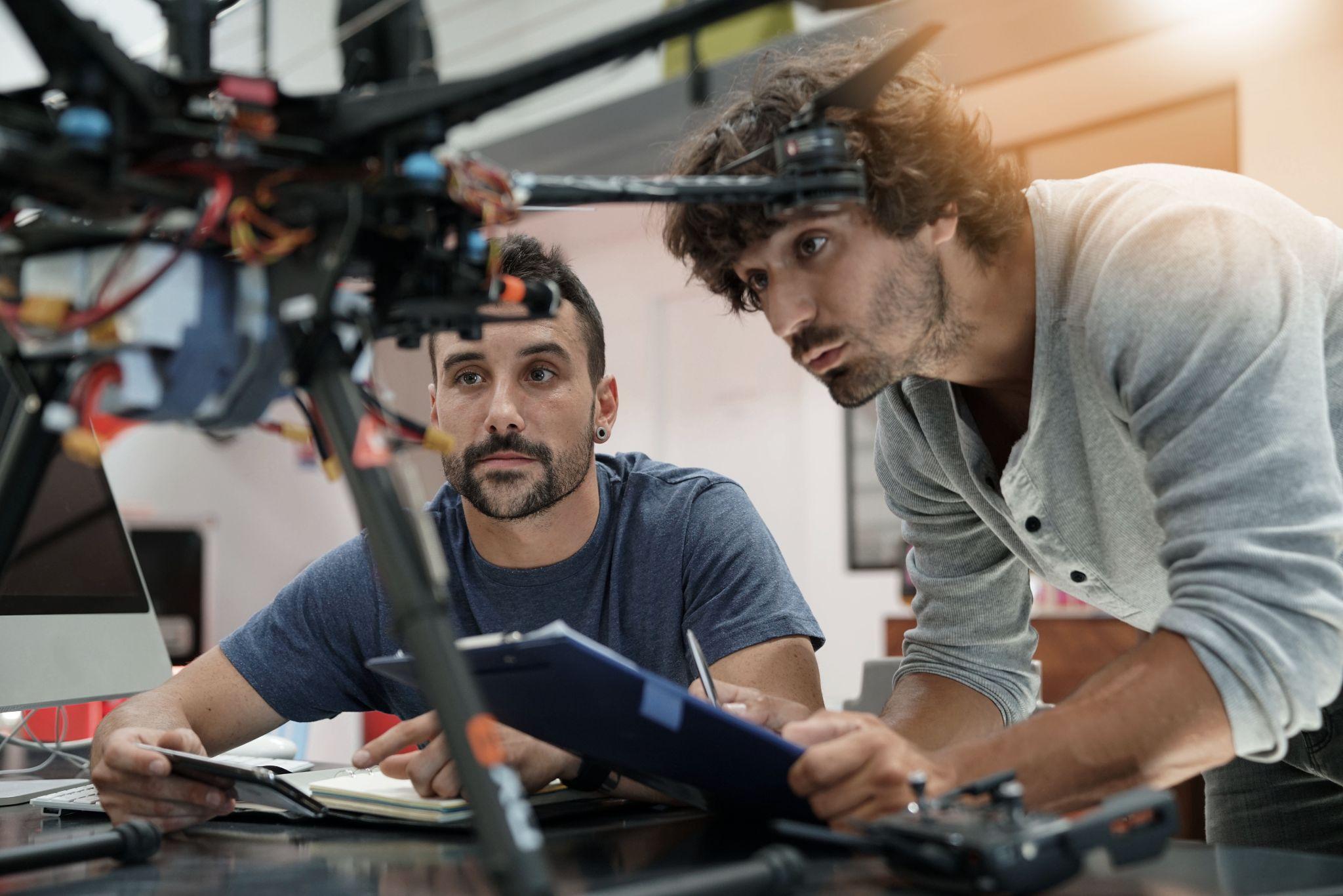 Two engineering students examining hardware together in a lab