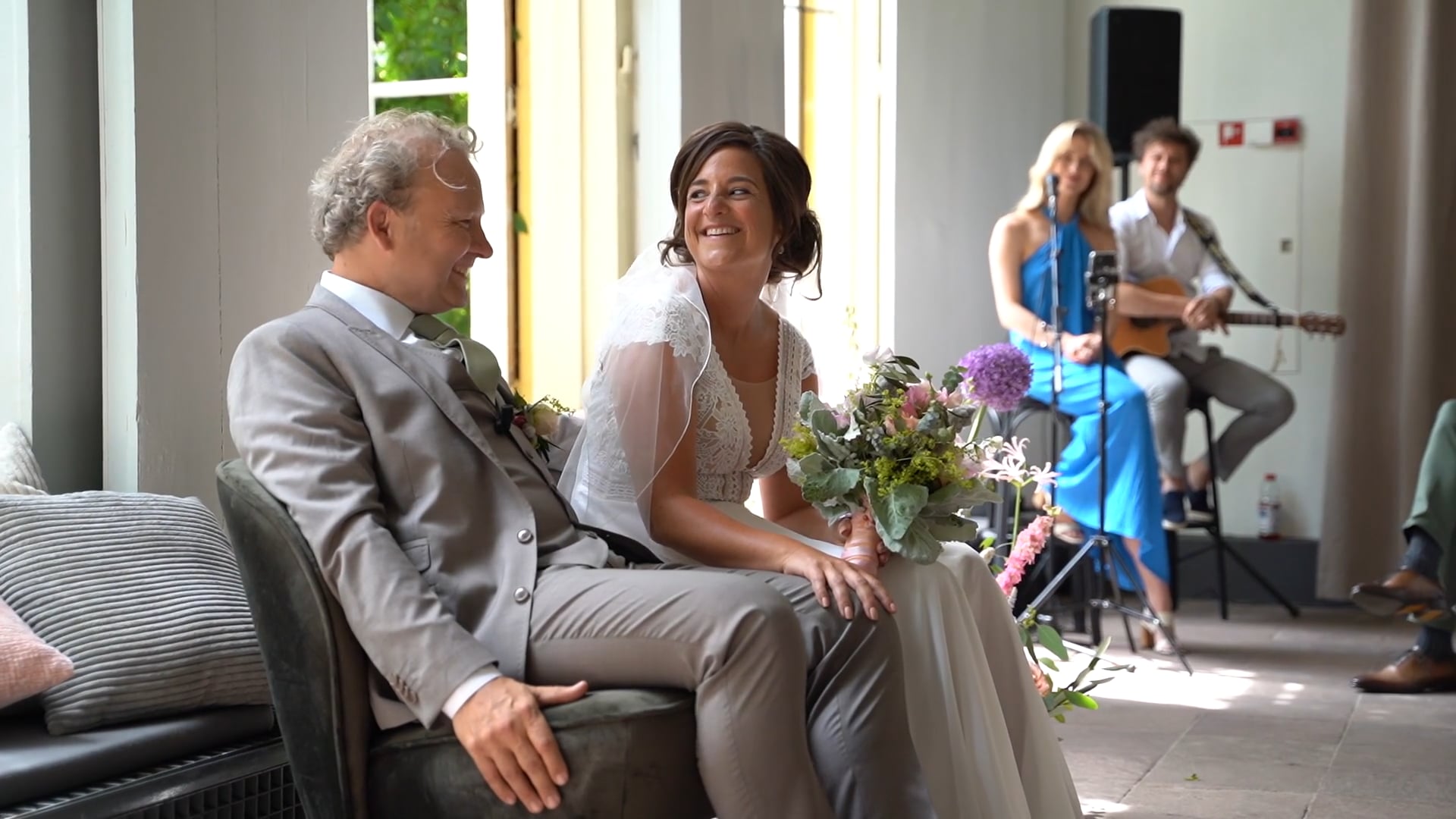 Cecilia en Coen zitten samen op een bank tijdens hun trouwdag.