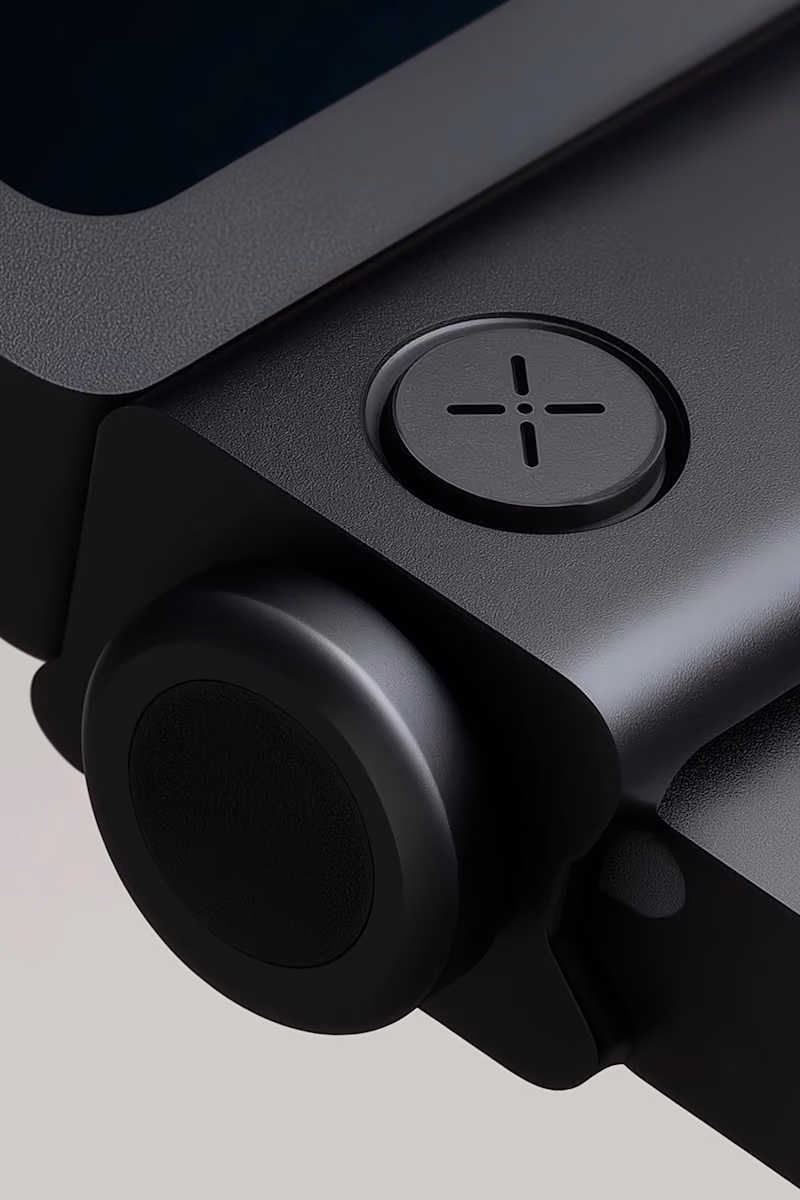 Close-up of a sleek black device corner with a round button and cross-shaped design on another button