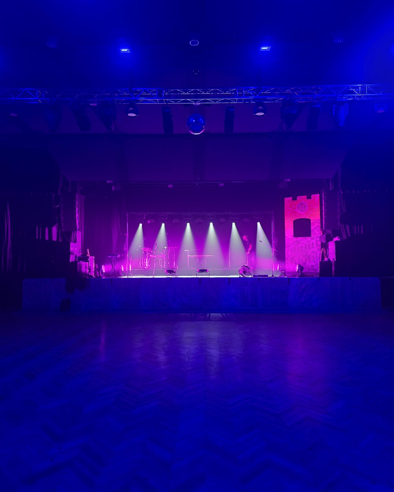 Empty hall with the stage lit in blue and magenta