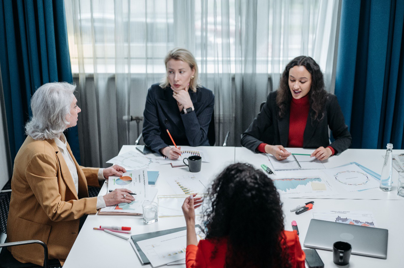 A diverse selection board reviewing candidate evaluation reports during a Grade 6 Executive Search process.