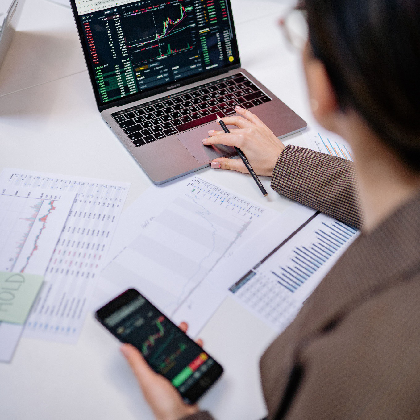 A financial analyst reviewing real-time data dashboards and market analytics to support public finance bodies.