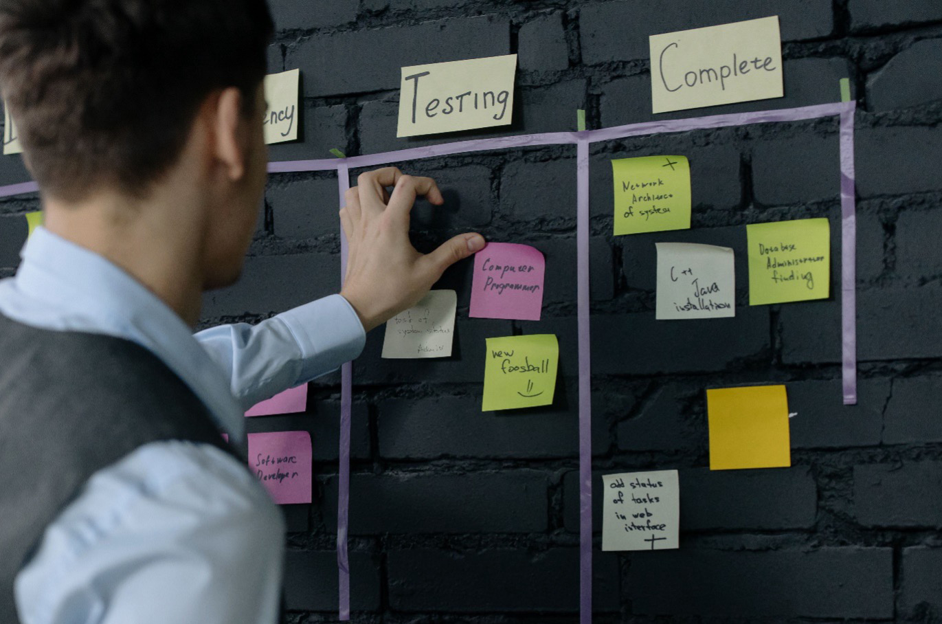 A product manager organising tasks on an agile Kanban planning board during a public sector digital recruitment project.