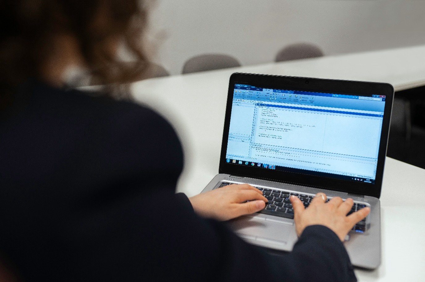A software engineer writing code on a laptop during a technical project.