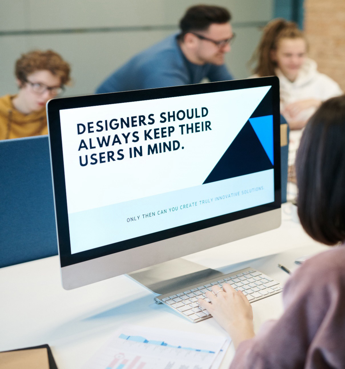 A digital designer reviewing user-centred design principles on a desktop computer screen during a public sector digital recruitment project.