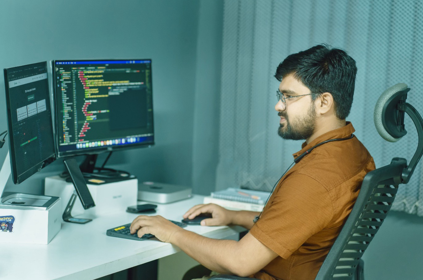 A data engineer developing algorithms and code pipelines on dual screens for public sector AI recruitment.
