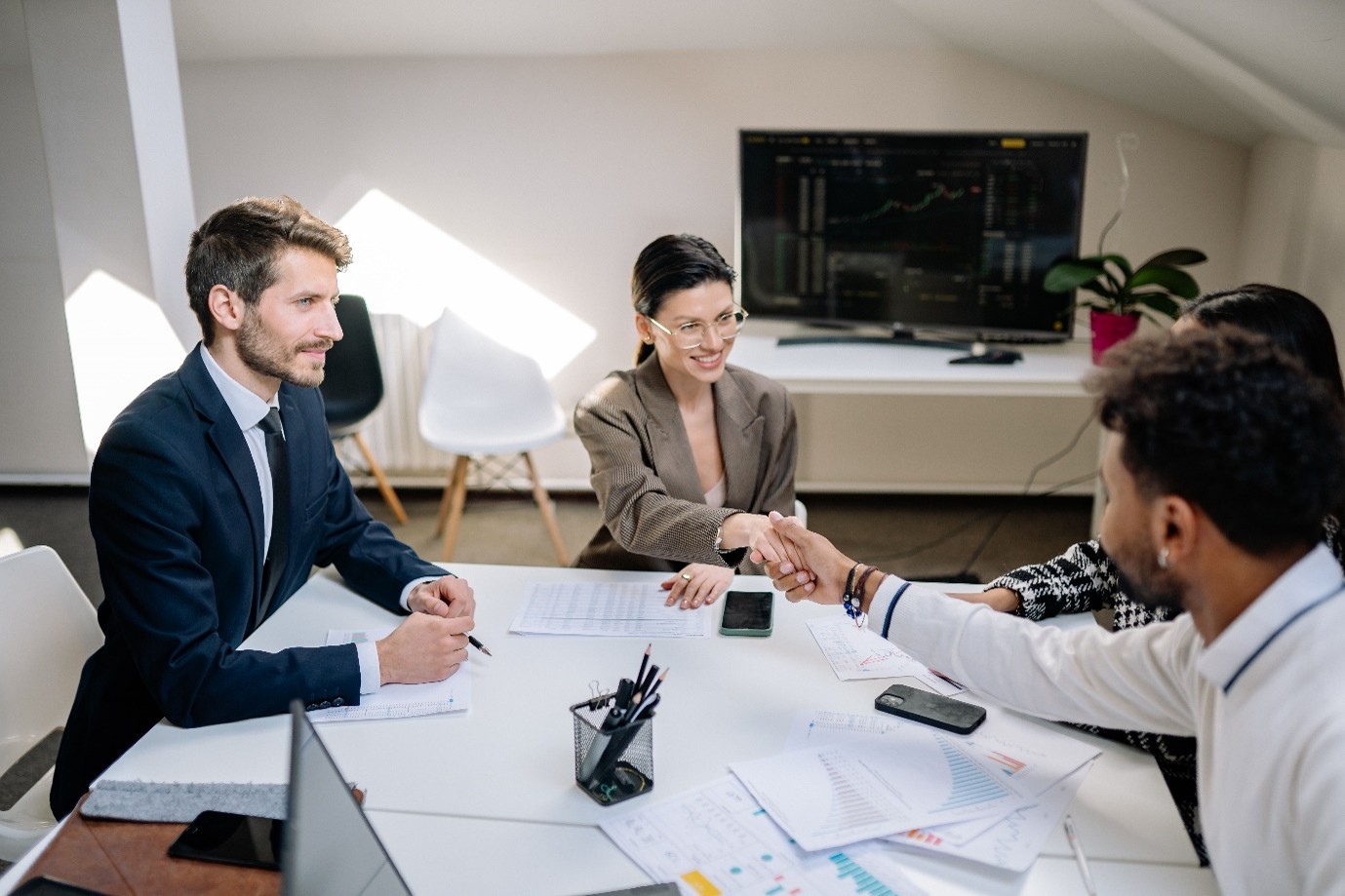 Commercial stakeholders shaking hands over a service contract agreement evaluated under public sector IR35 compliance rules.