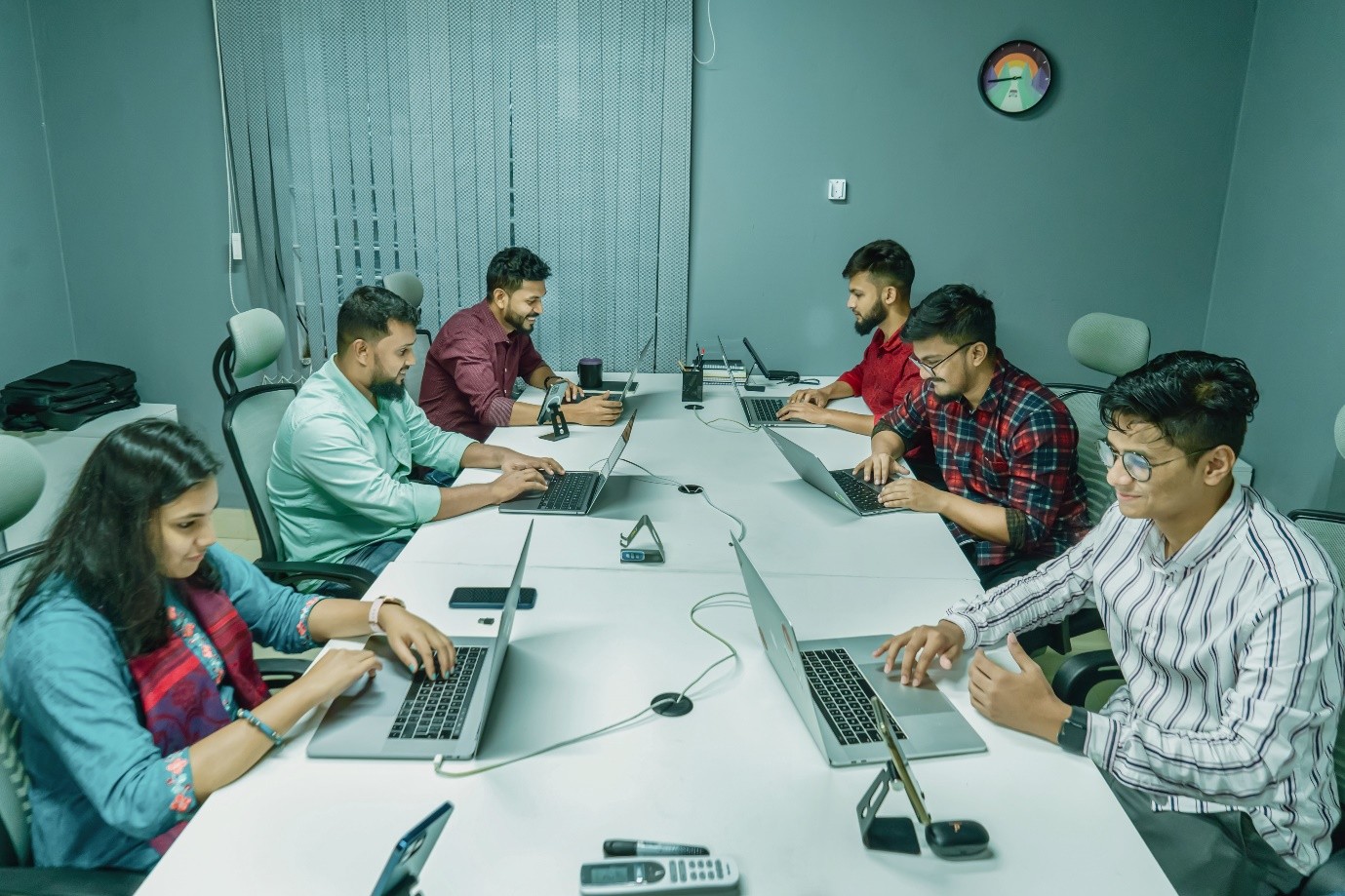 A multidisciplinary digital squad working on laptops to deliver public sector programmes governed by a statement of work.