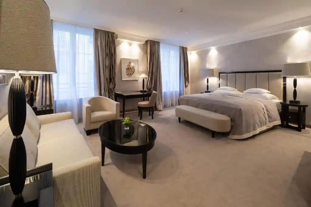 Elegantes Hotelzimmer mit großem Doppelbett, Sitzbereich und warmem, indirektem Licht.