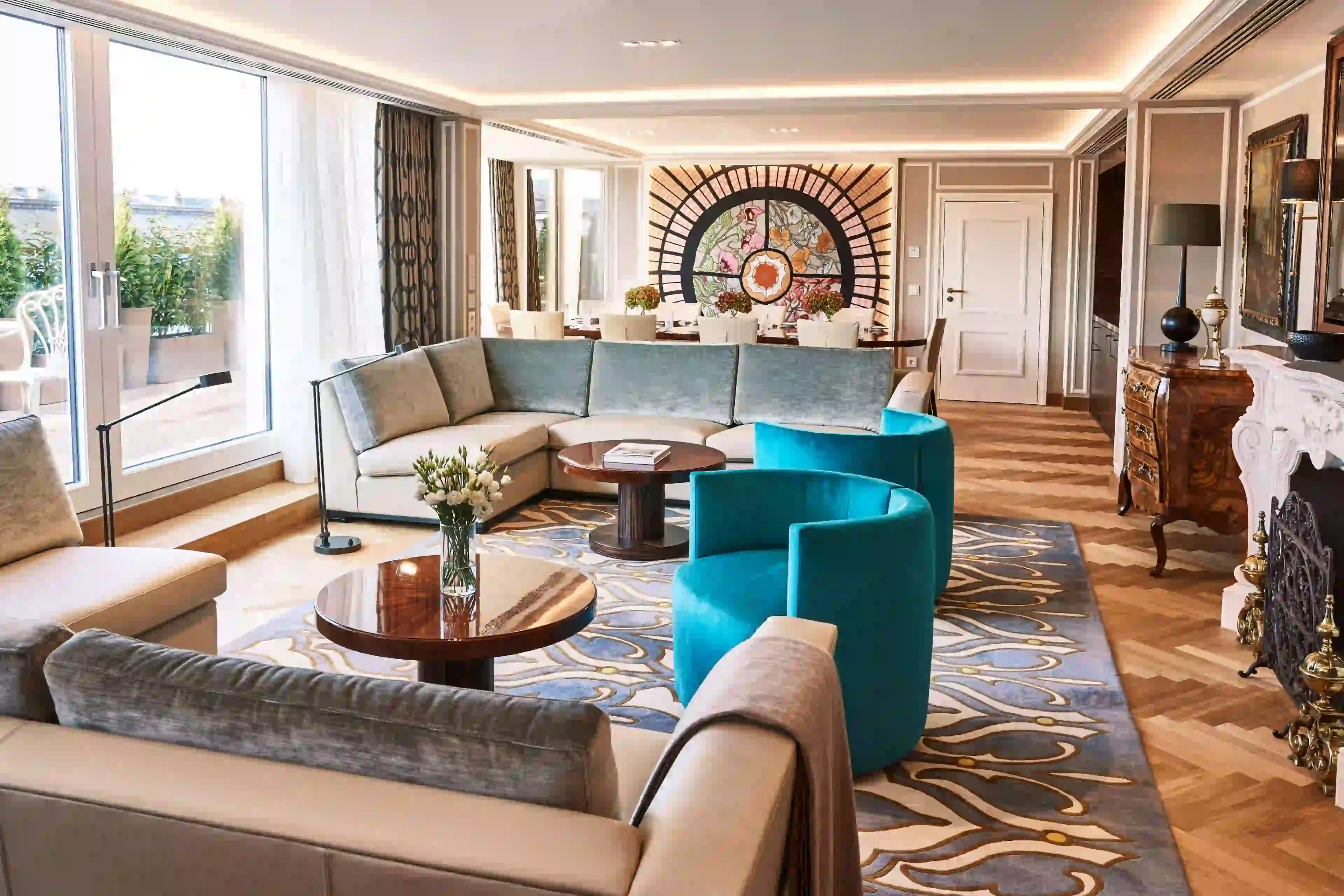 Stilvoll eingerichtete Hotelsuite mit großzügigem Wohnbereich, moderner Lounge-Ecke und großen Fenstern mit Stadtblick.