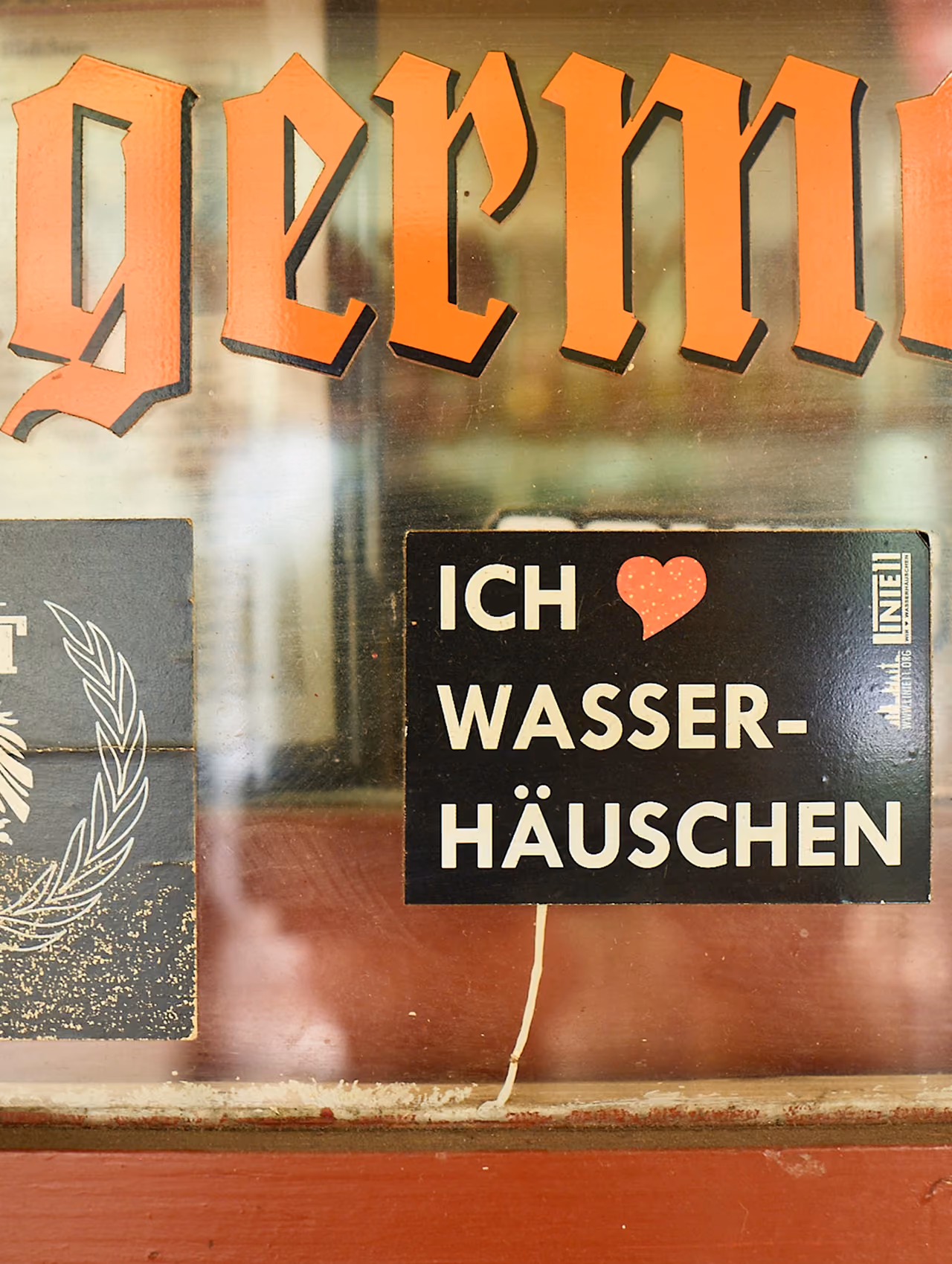 Schild mit der Aufschrift Ich liebe Wasserhäuschen im Fenster eines Kiosks