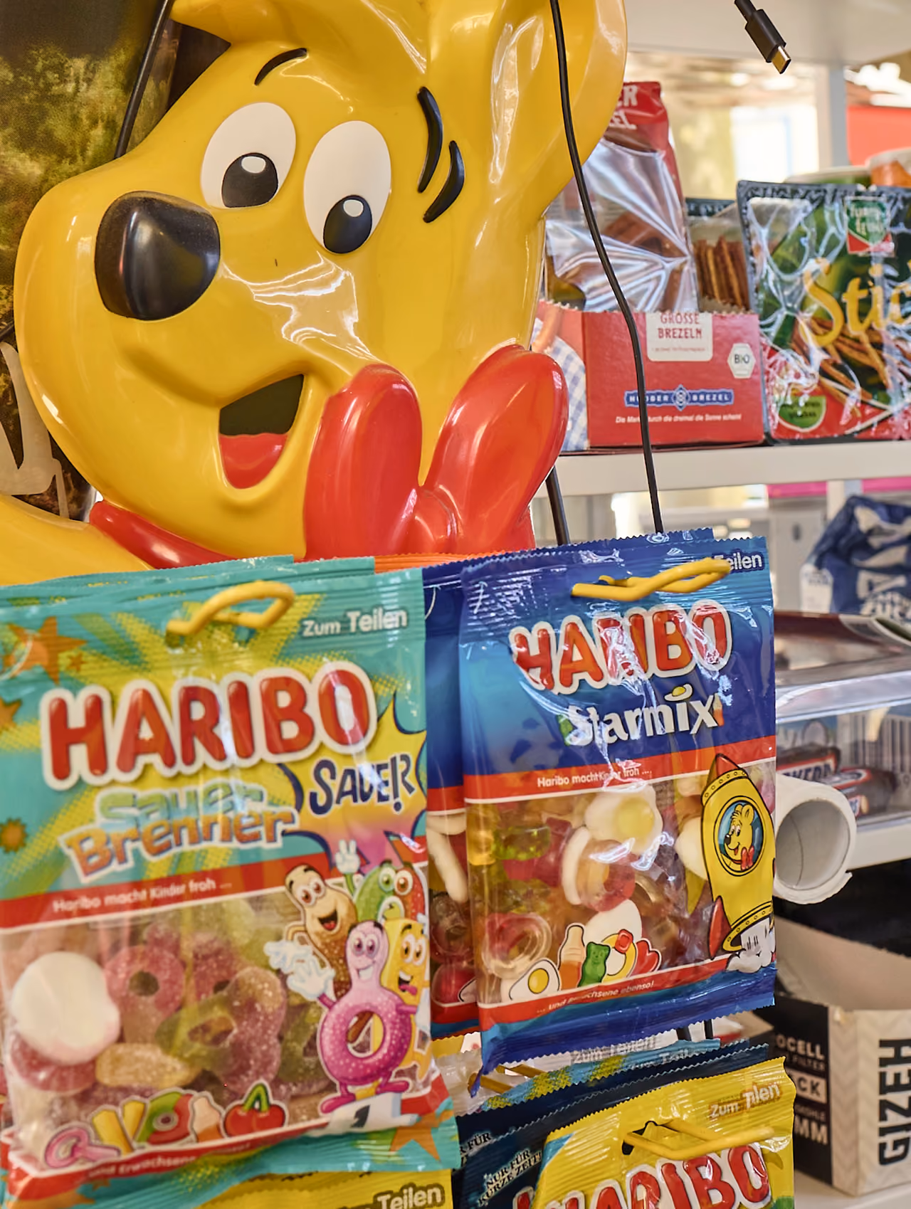 Goldbär-Figur und Fruchtgummi-Tüten auf dem Tresen eines Wasserhäuschens