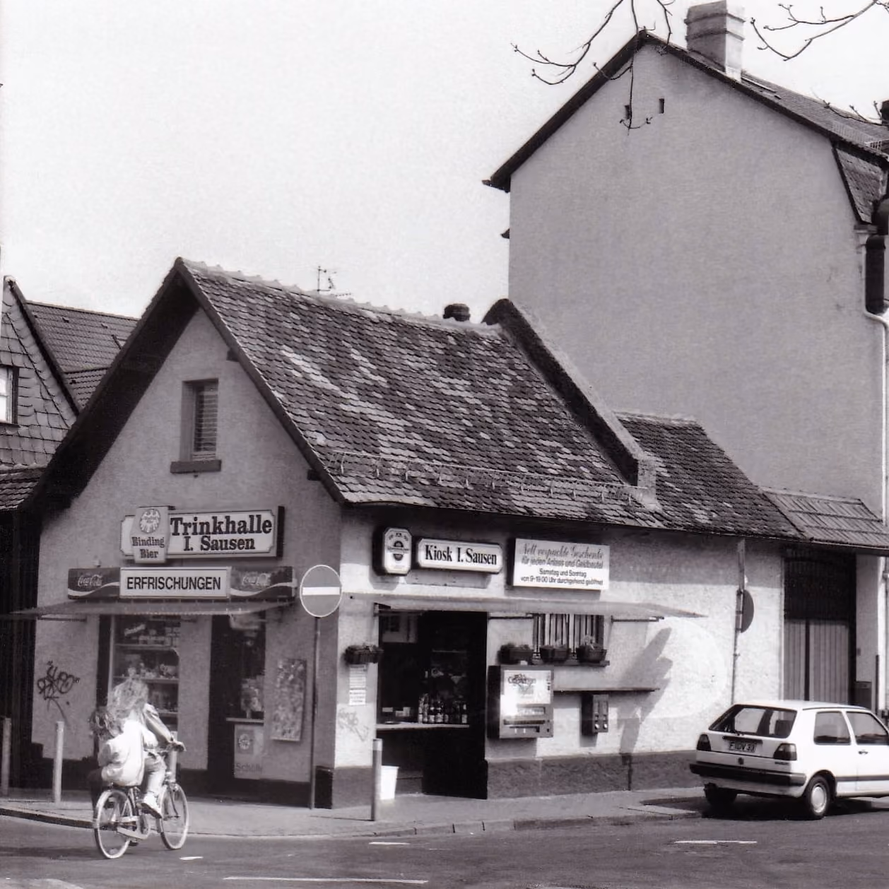 Historische Aufnahme der Trinkhalle Sausen an einer Frankfurter Straßenecke, davor eine Radfahrerin