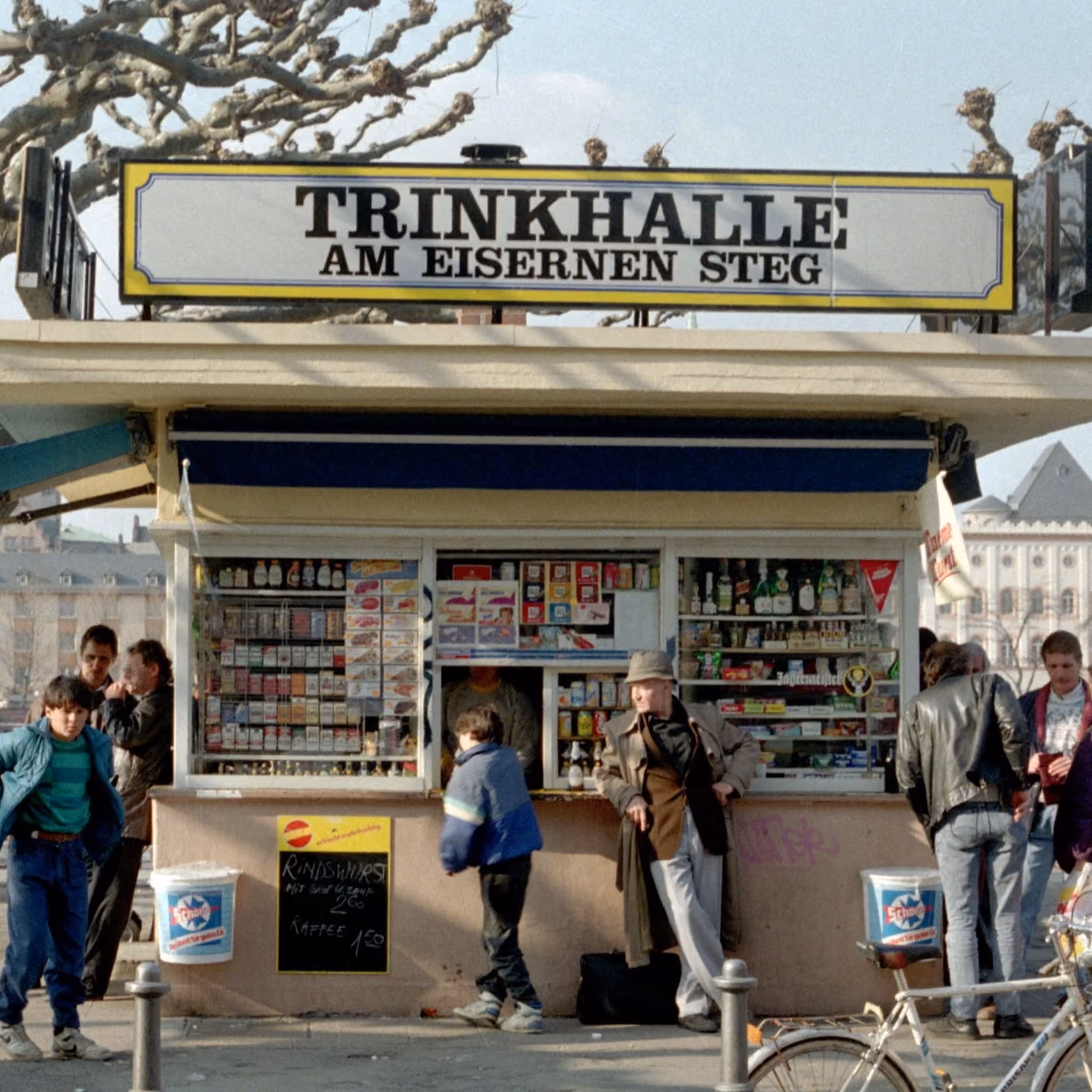 Trinkhalle am Eisernen Steg in Frankfurt, Kundinnen und Kunden stehen am Verkaufsfenster