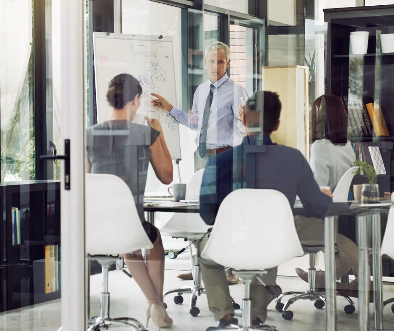 Colleagues in a meeting room during a whiteboard presentation