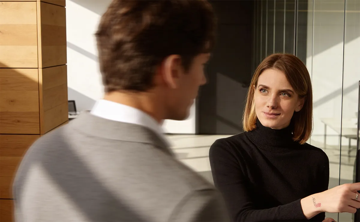 A man and a woman standing in front of a mirror.