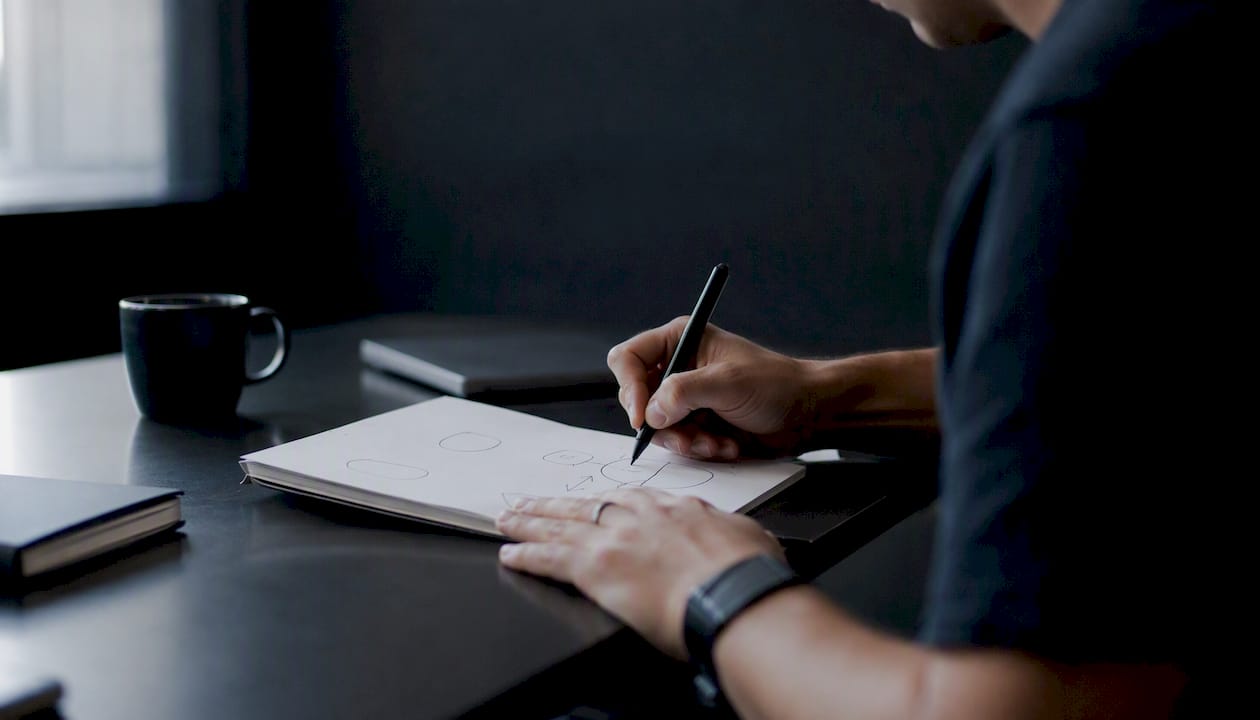 Hands making optimization notes for LinkedIn campaigns