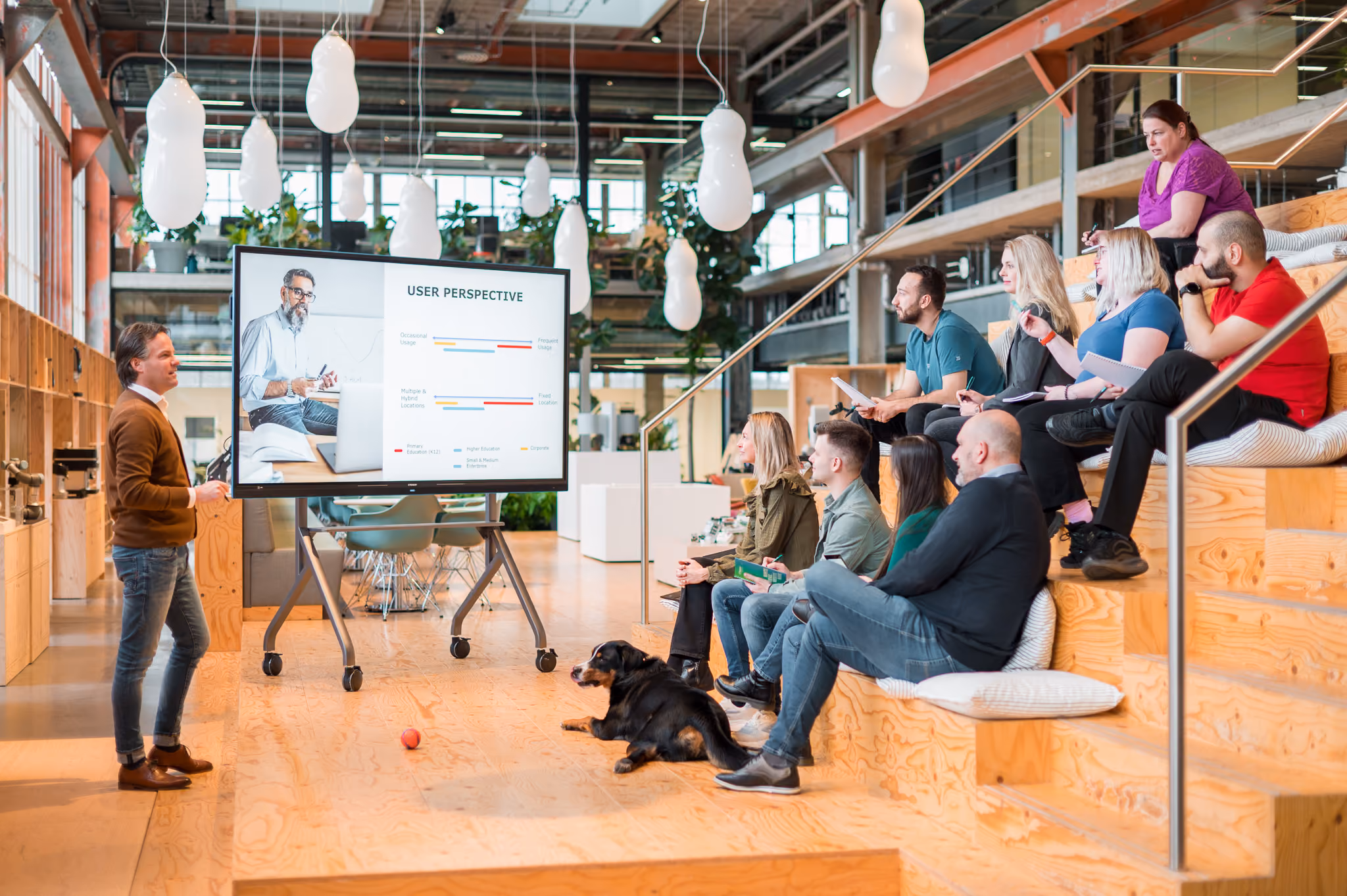 A man gives a presentation in a hole using a touch display, talking about the user's perspective. 