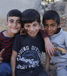 Three boys smiling together outdoors