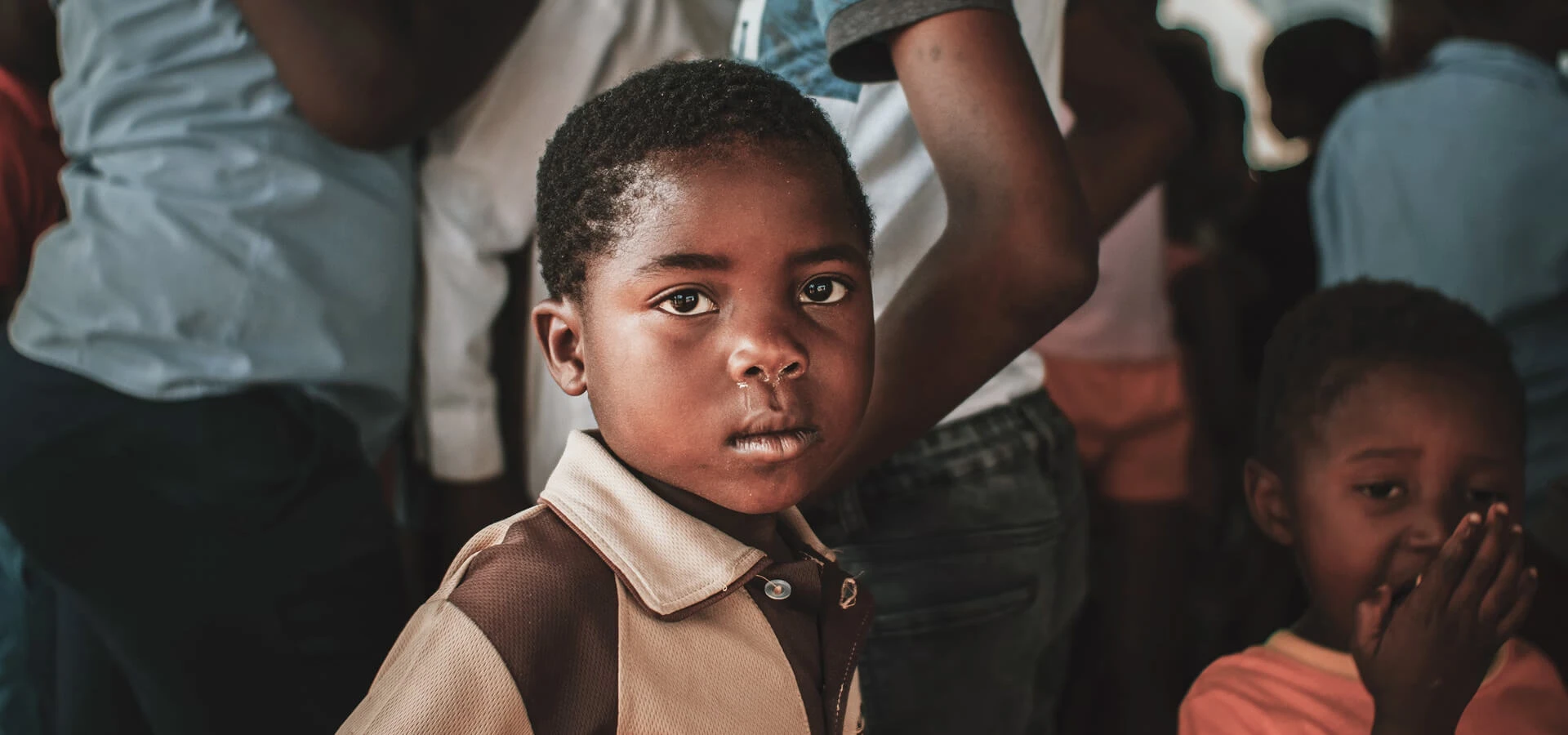 Young boy in school uniform, representing Karuna's child protection work during humanitarian emergencies