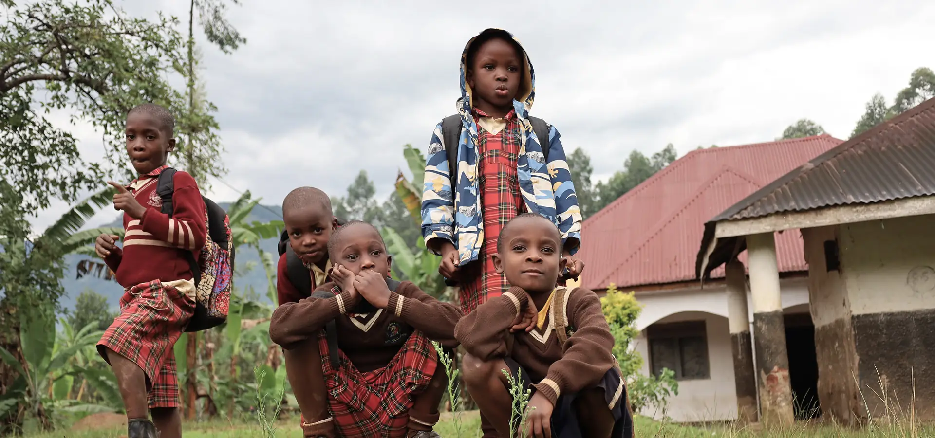 Children in school uniforms with backpacks at a rural safe space