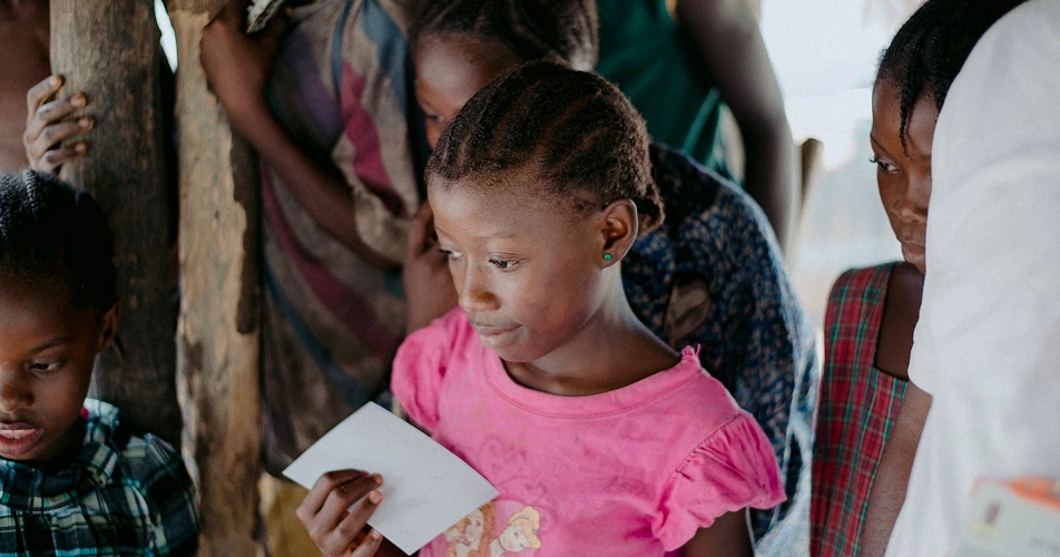 Girl reading during a group session in a temporary classroom