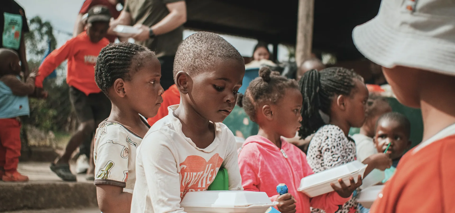 Children gathered at a community center receiving meal support