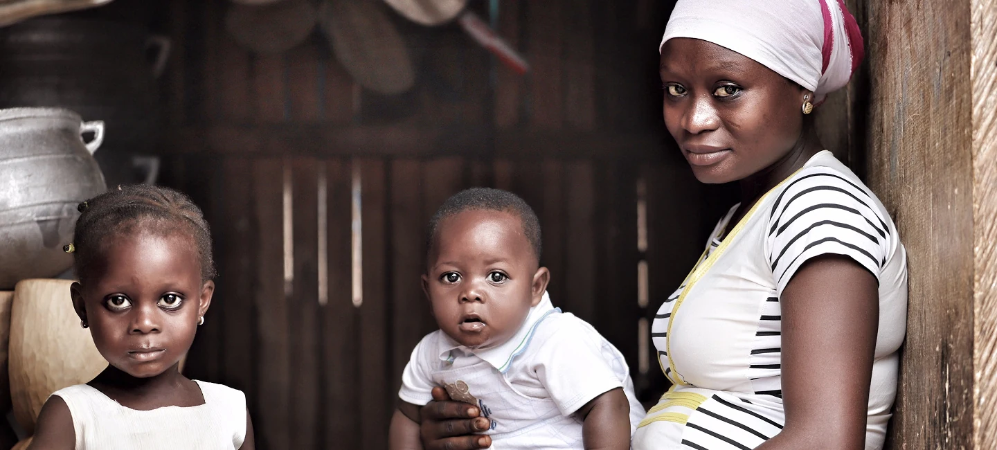 Mother with two young children standing together indoors after crisis recovery