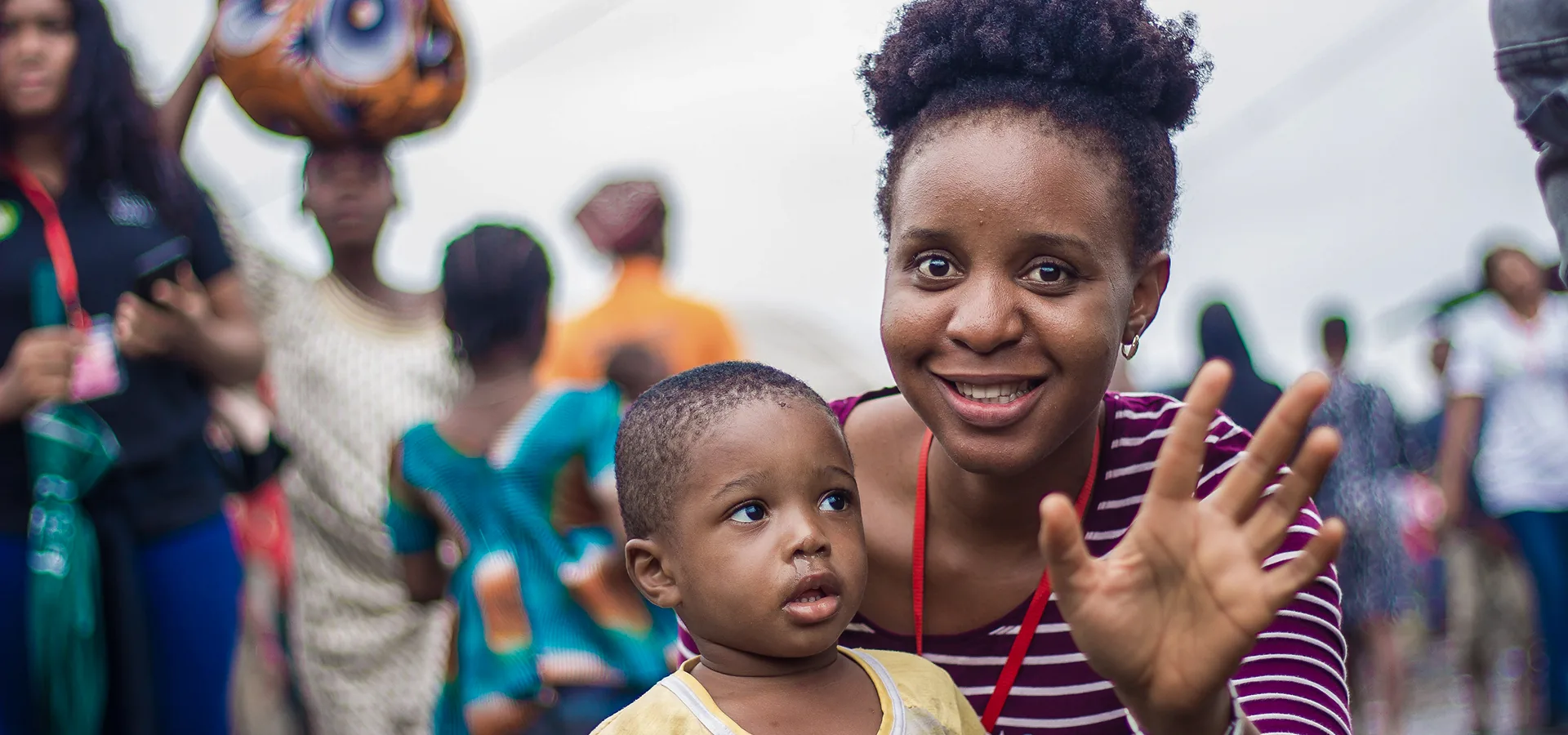 Aid worker smiling with a young child at a child safety program site