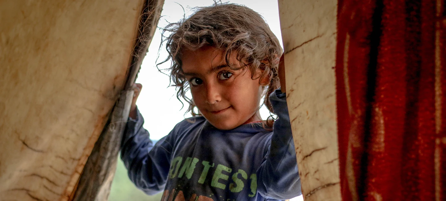 Young girl peeking through a tent opening