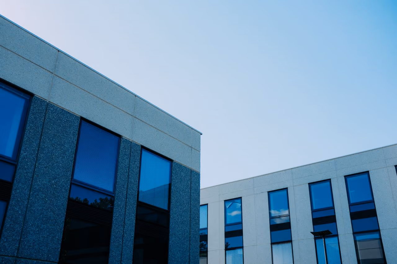 Modern office buildings with reflective blue windows under a clear sky.