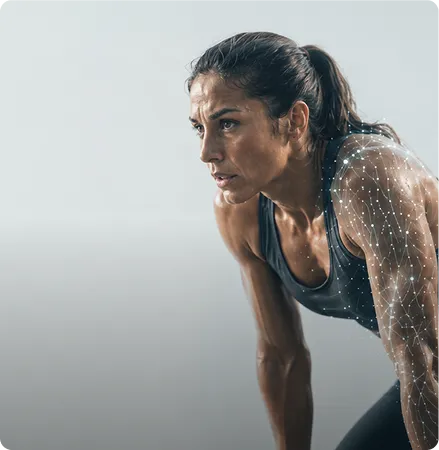 Femme sportive essoufflée regardant vers la gauche, portant un débardeur noir, avec des éléments graphiques sur son bras.