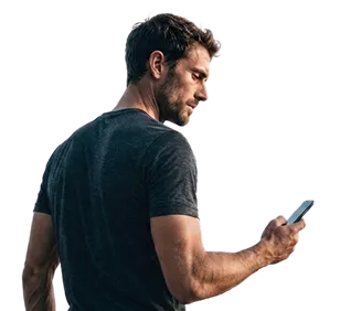 Homme en t-shirt sombre regardant un smartphone dans sa main droite.